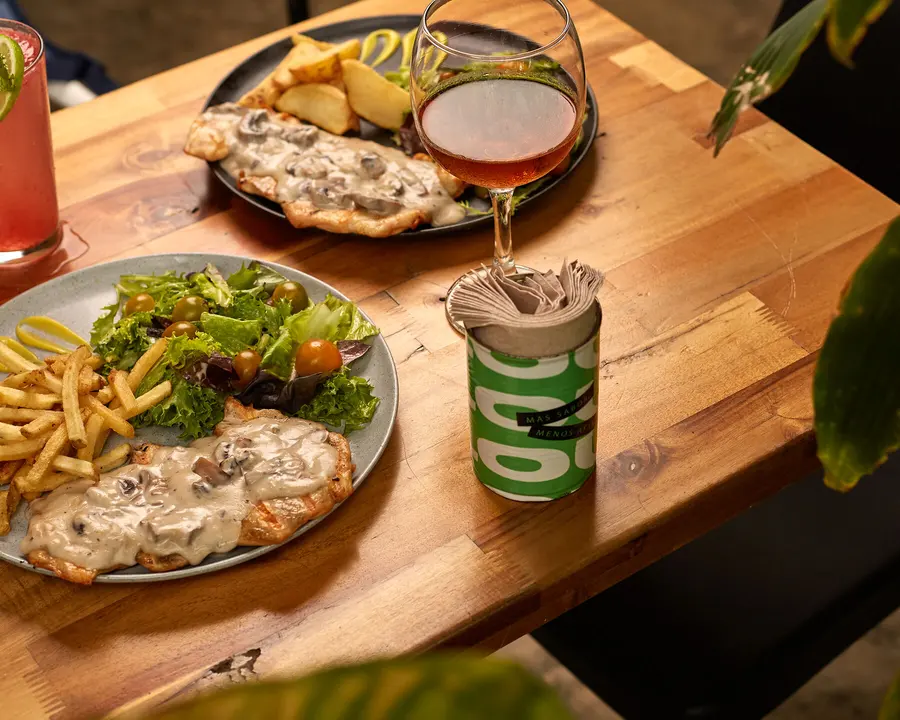 Mesa de SLOU con pollo, ensalada y bebidas