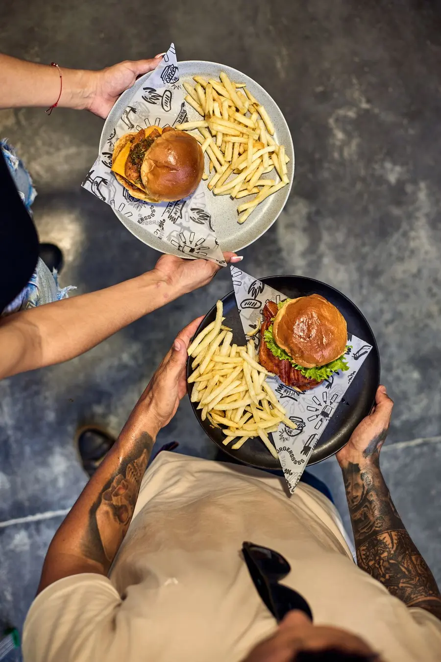 Meseros sirviendo burgers y papas, vista desde arriba
