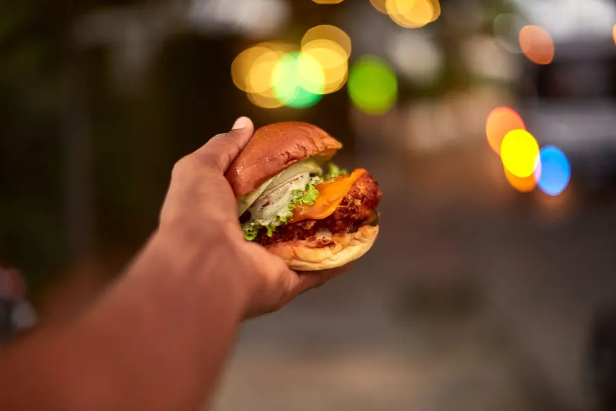 Burger en la mano, de noche